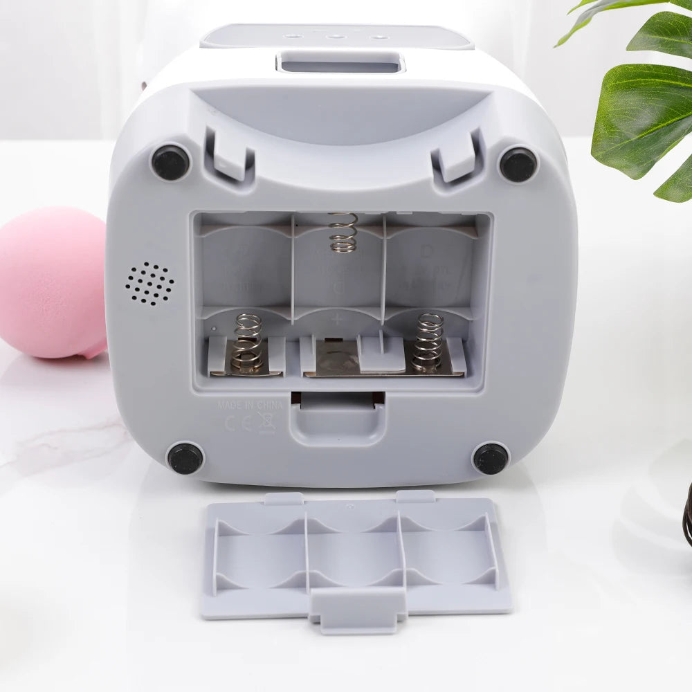 Automatic pet feeder for cats with LCD display and smartphone control, accompanied by a relaxed cat.